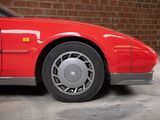 a red car parked in a garage with a brick wall in the background