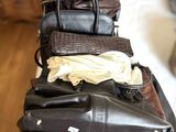 une pile de sacs à main posée sur un lit