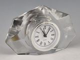 a glass clock with roman numerals on the face