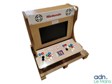 une console de jeux vidéo fabriquée en carton, posée sur une palette