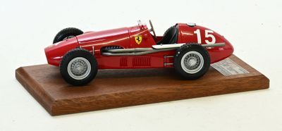 une maquette rouge d'une voiture de course posée sur un socle en bois
