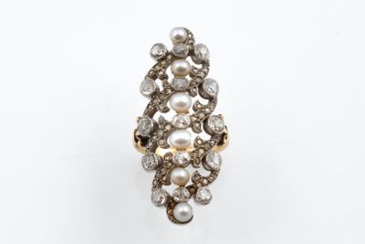 a close up of a ring with pearls and diamonds on a white surface