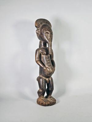 Grande statue masculine en bois patiné. Le ventre prohéminen…