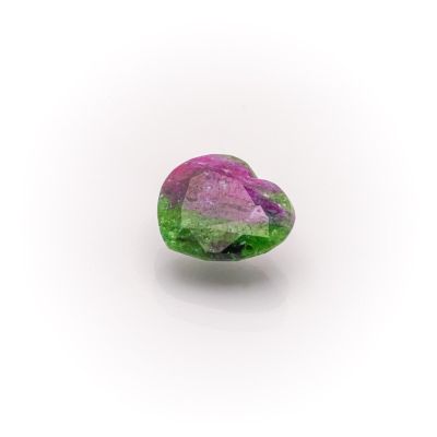 a close up of a pink and green stone on a white surface