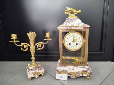 une horloge en or et deux lustres posés au sol
