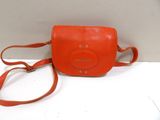 an orange purse sitting on top of a white table
