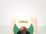 a box of coffee sitting on a table next to a cup