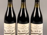 trois bouteilles de vin sont alignées sur une table