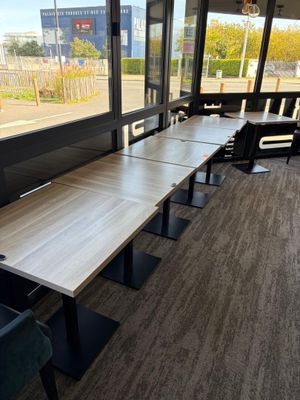 une longue table avec des chaises devant une fenêtre