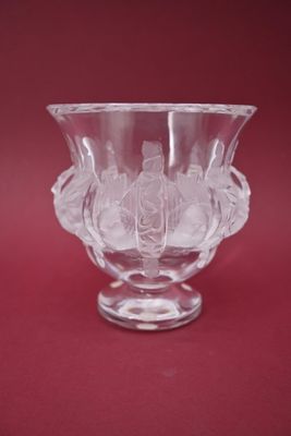 un vase en verre orné d'un motif sur un fond rouge