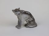 statue of a cat sitting on its hind legs on a white surface