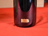a bottle of wine sitting on a table with a red cloth