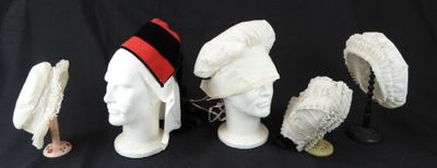 trois chapeaux et un porte-chapeaux sur fond noir