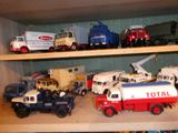 de nombreux camions miniatures posés sur une étagère dans une pièce