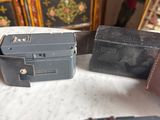 two old cameras and a wallet on a table
