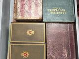 de nombreux livres anciens dans une boîte blanche posée sur une table