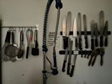 many knives hanging on the wall in the kitchen