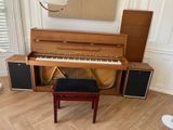 a piano in the corner of a room next to a chair