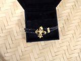 a black box with a gold fleur de lis brooch on it