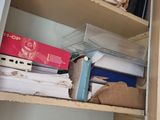 a closet with a lot of boxes and papers on the shelves