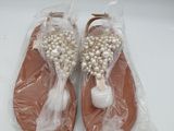 les chaussures sont emballées dans du plastique et ornées de perles