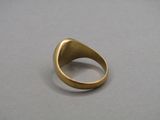 gros plan d'une bague en or sur une surface grise