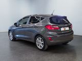 the back end of a gray car parked in a showroom