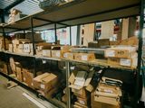 Les cartons sont empilés sur une étagère dans un entrepôt où se trouvent de nombreux cartons
