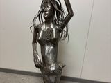 statue of a woman with long hair holding her hands up in the air