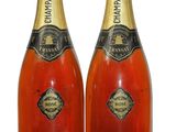 two bottles of champagne are sitting next to each other on a white surface