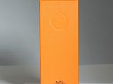 une boîte orange posée sur une table près d'un mur blanc