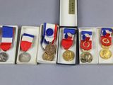cinq médailles et une médaille dans une boîte posée sur une table