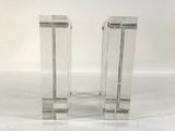 pair of clear acrylic lucine bookends on a white surface
