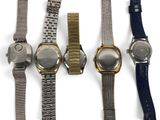 three watches are lined up in a row on a white surface