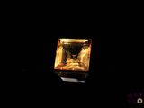 a close up of a square yellow diamond on a black background