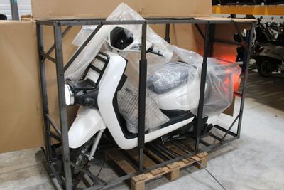 un scooter posé sur une palette dans un entrepôt