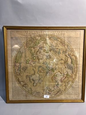 une vieille carte du monde dans un cadre doré accrochée à un mur blanc