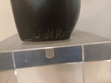 a black vase sitting on top of a metal shelf