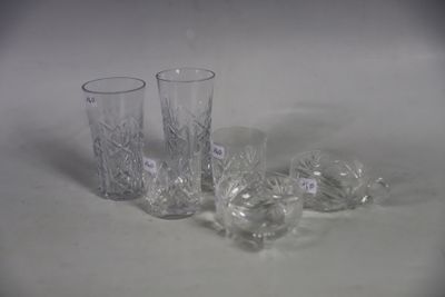four glass vases sitting on a table with labels on them