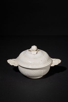a white bowl with a lid on a black surface