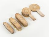four wooden brushes are lined up in a row on a white surface