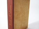 an old book sitting on top of a white table next to a white wall