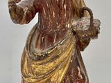 une image représentant une statue d'une femme tenant un panier de fleurs
