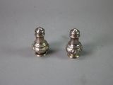 two silver salt and pepper shakers sitting on a table