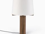 une lampe de table en bois surmontée d'un abat-jour blanc