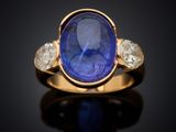 a gold ring with a blue sapphire and three white diamonds