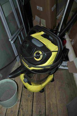 un aspirateur jaune et noir posé sur un parquet