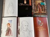 several books are open on a table with a drawing of a woman