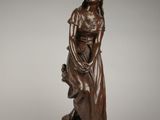 une statue antique en bronze représentant une femme tenant un enfant dans ses bras