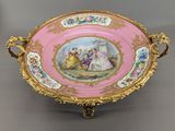 an image of a pink and gold plate with a painting on it